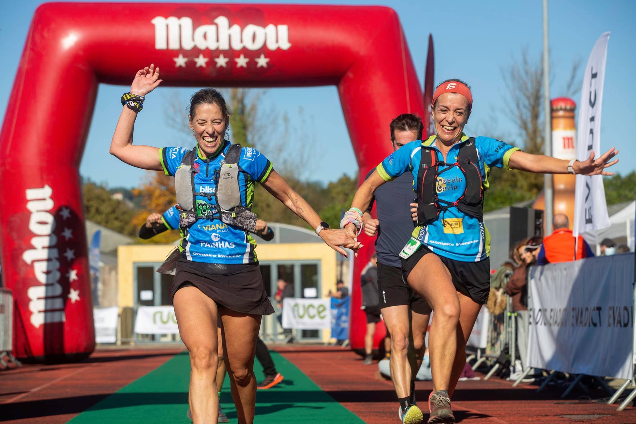 Two women Finisher in a trail running race holding each other hands