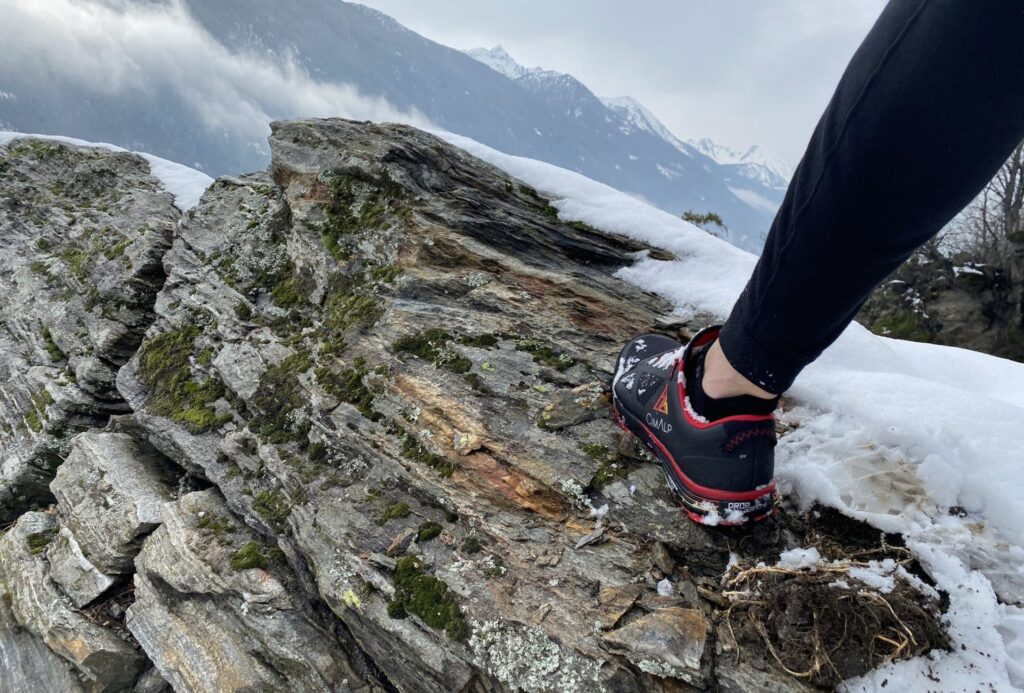 Scarpe di trail running marca CimAlp appoggiata su una roccia di fronte al Monte Bianco