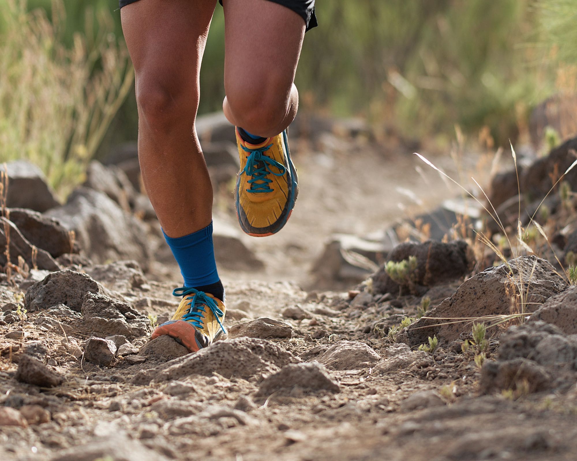 Gambe di un trail runner con i muscoli in vista mentre fa esercizi di forza sulle gambe