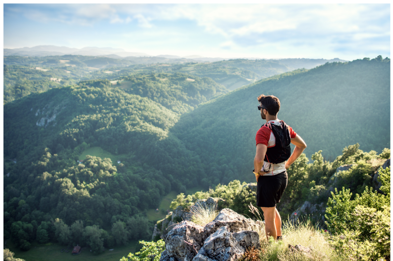 Trail runner sulla cima di una montagna che ammira il paesaggio dopo un allenamento