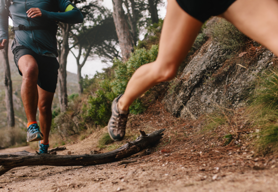 A trail runner man and woman are running on trails of a mountain