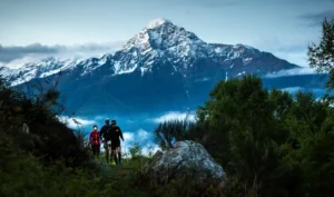 Ultra Trail lago di como gara trail running, trail runner corrono allumbrunisre sul percors ocn alle spalle la montagna innevata delle Grigne