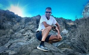 TRM coach su un sentiero di montagna con materiali, attrezzatura e abbigliamneto trail running estivo